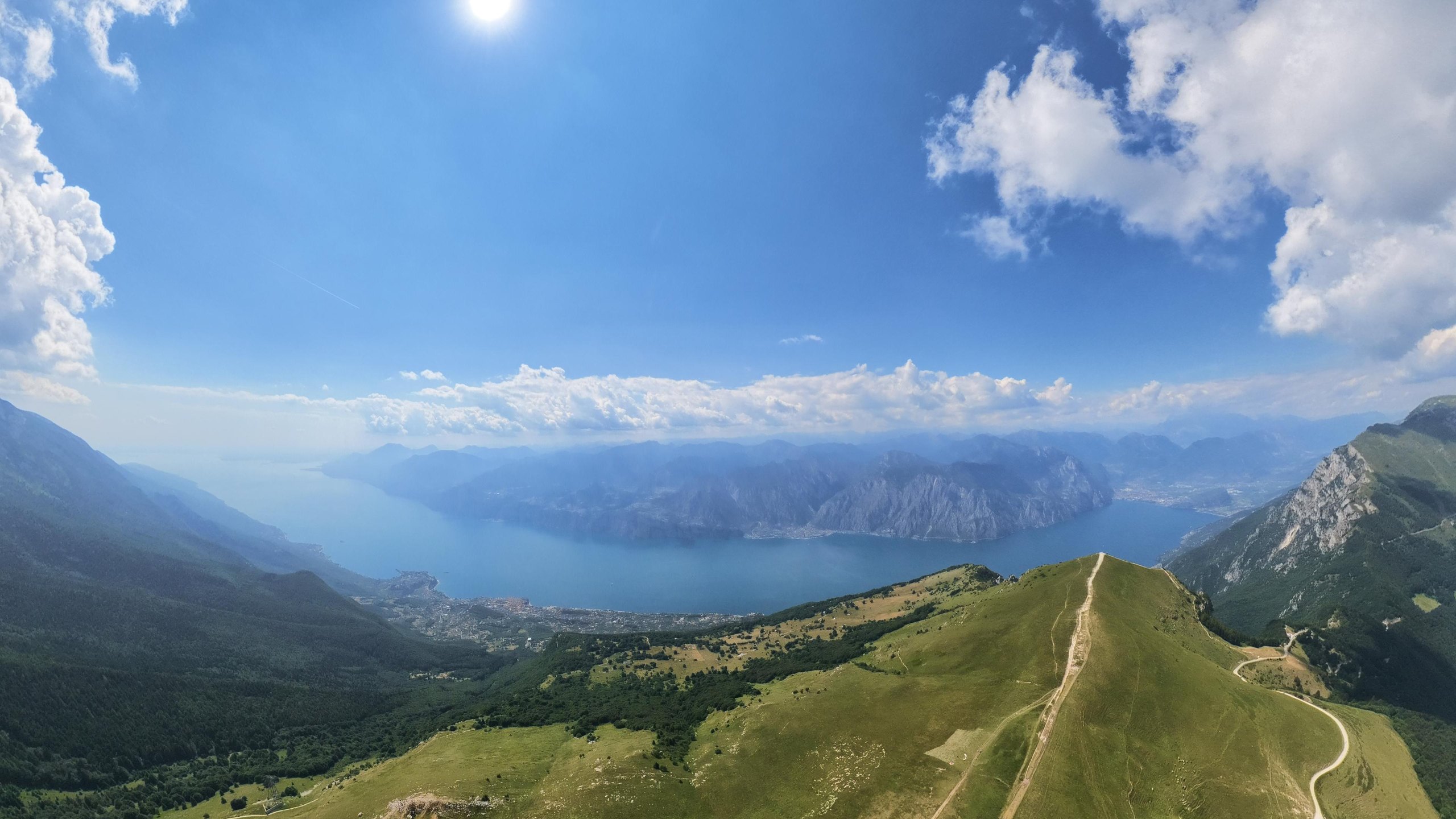 Lago di Garda visto dal Monte Baldo, cresta erbosa e cielo d'estate